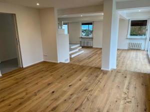 an empty room with wooden floors and white walls at Holiday Home mit Pool by Interhome in Nürtingen