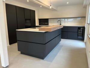 a large kitchen with black cabinets and a sink at Holiday Home mit Pool by Interhome in Nürtingen +4 photos