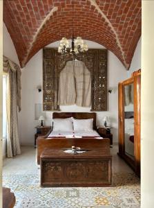 a bedroom with a bed and a chandelier at Guesthouse DarHamdoun in Ḩammām al Ghazzāz +70 photos