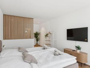a bedroom with a white bed with a flat screen tv at Apartment Loft Seven by Interhome in Root +32 photos