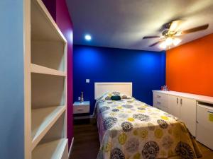 a bedroom with a bed and a blue wall at Hotel Los Cantaros in Rosarito Beach