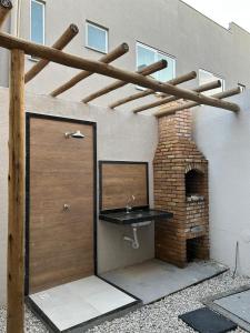 a garage with a sink next to a brick oven at Recanto da Frida in Caucaia