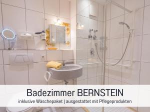 a white bathroom with a shower and a sink at Apartment BERNSTEIN by Interhome in Wertach +10 photos