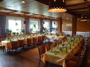 a dining room with long tables and chairs at Weigands Hotel Peter in Reinhardshagen
