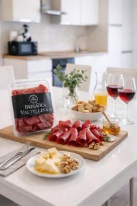 a table with cheese and meats and glasses of wine at Valtellinaresidence in Sondrio +6 photos
