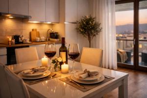 a table with two glasses of wine and candles at Valtellinaresidence in Sondrio