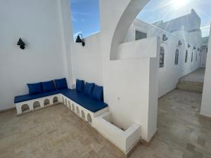 a room with a blue couch in a white wall at Guesthouse DarHamdoun in Ḩammām al Ghazzāz