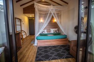 a bedroom with a bed with a canopy at Slon Ella in Ella