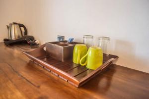 a tray with two yellow mugs on a wooden table at Slon Ella in Ella