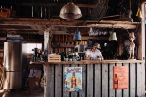 a man standing behind a bar with a bottle of beer at SleepCleeanGo L2 in Tofta