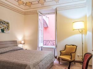 a bedroom with a bed and a chair and a window at Apartment Emanuela by Interhome in Alassio