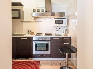 a kitchen with a stove and a microwave at Apartment Emanuela by Interhome in Alassio +15 photos