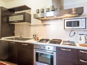 a kitchen with a stove and a microwave at Apartment Emanuela by Interhome in Alassio