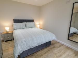 a bedroom with a large bed with a mirror at Binevenagh Point Cabin in Limavady