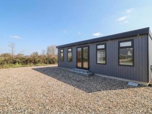 a black tiny house sitting on a gravel lot at Binevenagh Point Cabin in Limavady