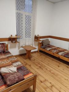 a room with two beds and a table and a window at Скай Румс -2 in Sofia