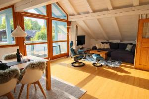 a living room with a couch and a table at ChiemseeRefugium - Ferienwohnung Park in Bernau am Chiemsee