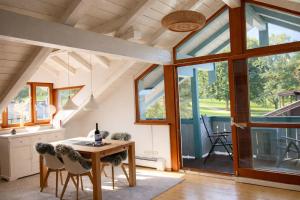 a room with a table and chairs and windows at ChiemseeRefugium - Ferienwohnung Park in Bernau am Chiemsee