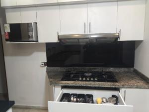 a kitchen with a stove and a microwave at CRIMIg in Huamboya +5 photos