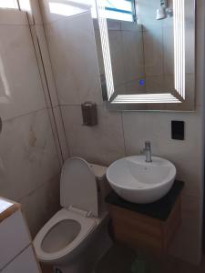 a bathroom with a sink and a toilet and a mirror at CRIMIg in Huamboya