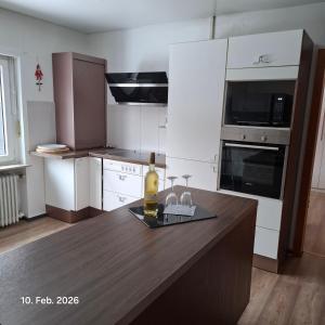 a kitchen with a table with a bottle of wine on it at Casa Calali haustierfreundlich u barrierefrei in Bad Endbach +13 photos