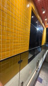 a yellow tiled wall with a window in a bathroom at Pousada Rafael in Juazeiro do Norte