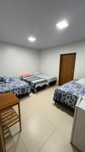 a room with two beds and a table in it at Pousada Rafael in Juazeiro do Norte +17 photos