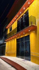 a yellow brick building with windows and a balcony at Pousada Rafael in Juazeiro do Norte