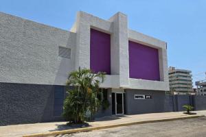 ein Gebäude mit violetten Bildschirmen an der Seite in der Unterkunft Hotel Itto Acapulco in Acapulco