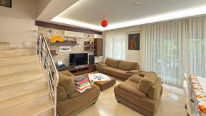 a living room with two couches and a television at Paradise Town Villa Premium in Belek
