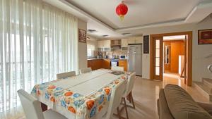 a dining room with a table and a kitchen at Paradise Town Villa Premium in Belek