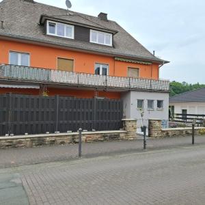 a house with a black fence in front of a street at Casa Calali haustierfreundlich u barrierefrei in Bad Endbach