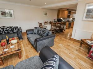 a living room with couches and a table and a kitchen at High Hemmel House in Embleton