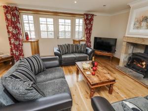 a living room with two couches and a fireplace at High Hemmel House in Embleton