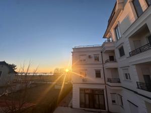 a building with the sun setting behind it at Panonski Mornar in Palić