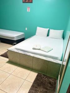 a bed in a room with a blue wall at Pousada Vitória in Iranduba