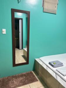 a mirror in a bathroom with a blue wall at Pousada Vitória in Iranduba +5 photos