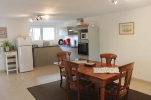 een keuken en eetkamer met een houten tafel en stoelen bij Le Clos Saint Morand in Balschwiller