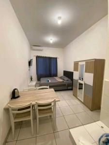 a living room with a table and chairs and a bed at Hotel Raudah Kapuas in Kualakapuas +18 photos