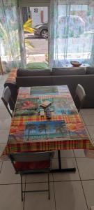 a table with a blanket on top of it in front of a couch at Cocon Alizé - Studio cozy, Port-Louis centre, plage à 10 min à pied in Port-Louis