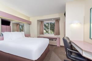 una camera d'albergo con un grande letto e una scrivania di Knights Inn Allentown ad Allentown