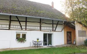 uma casa branca com mesa e cadeiras em Le Clos Saint Morand em Balschwiller