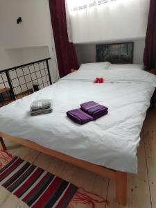 a white bed with two purple towels on it at Apartman "Galerija" in Pirot