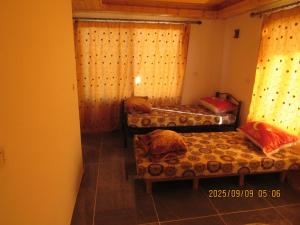 a room with three beds and a window at اكواخ الملول عجلون 2 in Ajloun