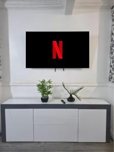 a tv on a white wall in a living room at Costa Home - 3 bed house with free on-street parking - ideal for workers in Middlesbrough