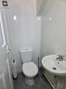a white bathroom with a toilet and a sink at Costa Home - 3 bed house with free on-street parking - ideal for workers in Middlesbrough