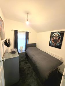 a bedroom with a bed and a picture of a dog on the wall at Costa Home - 3 bed house with free on-street parking - ideal for workers in Middlesbrough