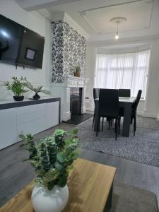a living room with a table and a dining room at Costa Home - 3 bed house with free on-street parking - ideal for workers in Middlesbrough
