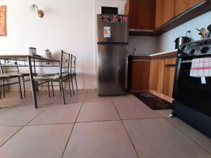 a kitchen with a stainless steel refrigerator and a table at Reñaca - Primera linea de playa con gran terraza in Viña del Mar +8 photos