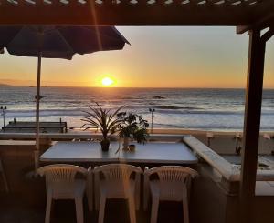 a table and chairs with a view of the ocean at Reñaca - Primera linea de playa con gran terraza in Viña del Mar